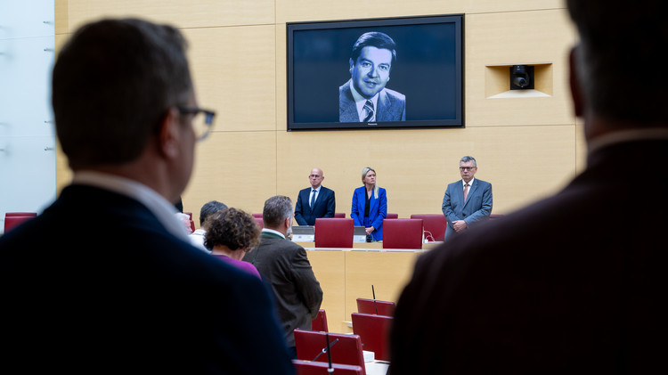 Rückanansicht zweier Abgeordnete vor einem Schwarzweiß-Foto von Hans Maier