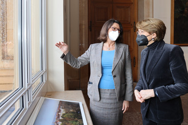 Landtagspräsidentin Ilse Aigner und Anne-Marie Descôtes blicken aus dem Fenster des Maximilianeums auf München. 